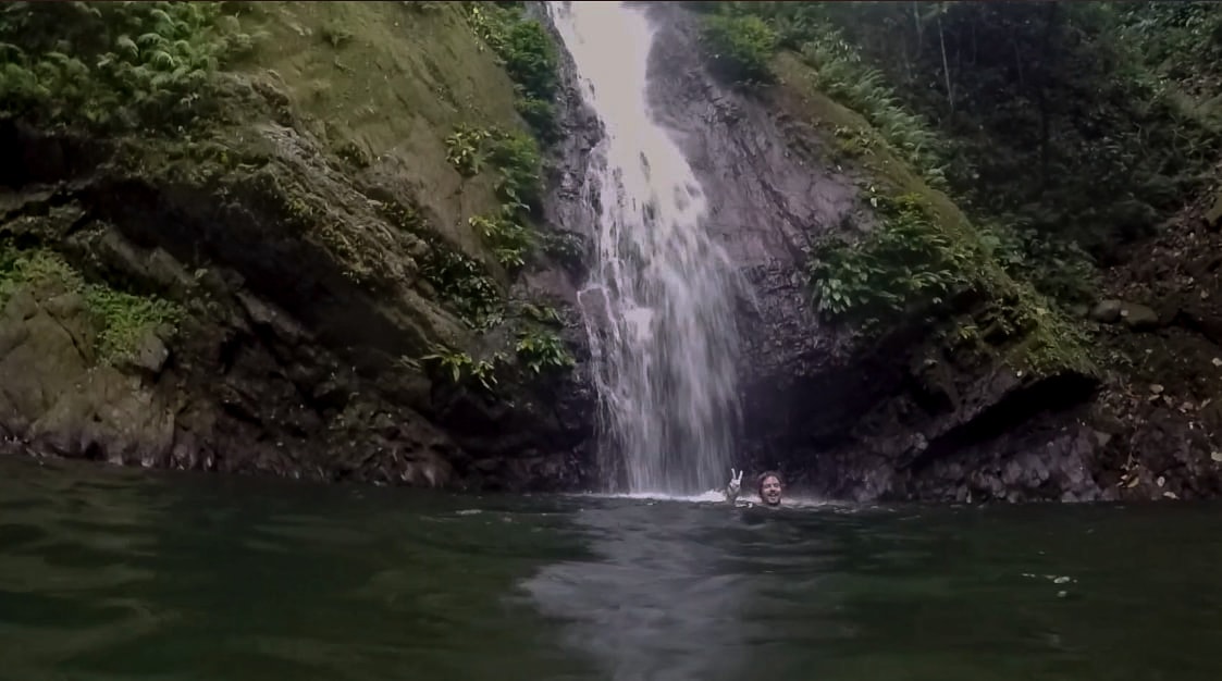 lenny through paradise enjoying the water and making peace sign at kabigan falls waterfall in pagudpud ilocos norte philippines